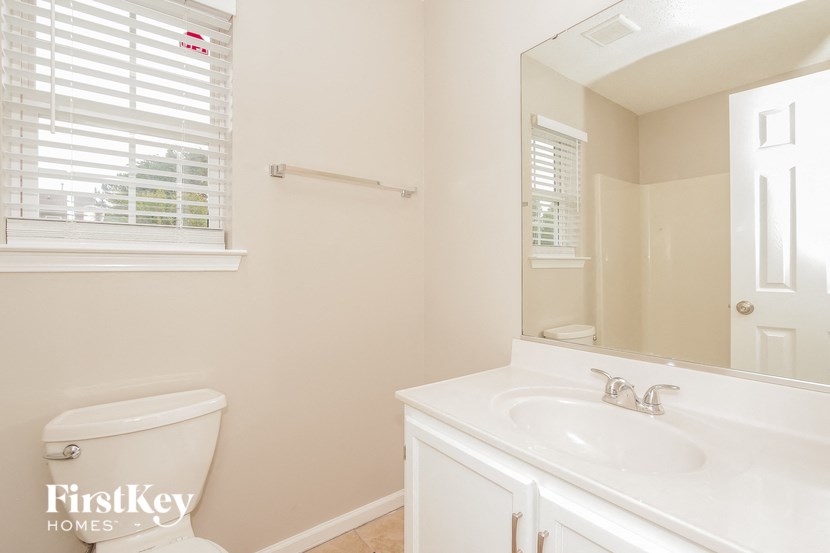 a bathroom with a toilet and a sink and a mirror