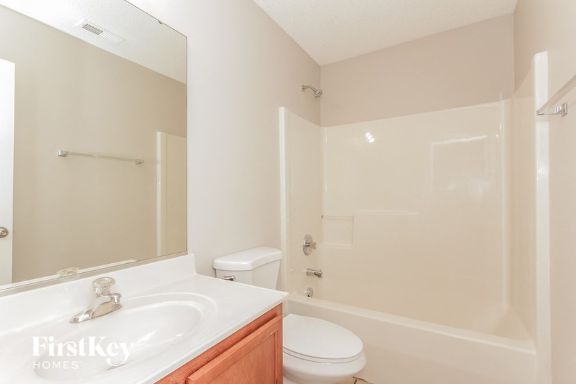 a bathroom with a sink toilet and a mirror