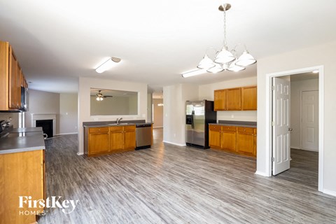 A spacious kitchen with wooden cabinets and a grey countertop.