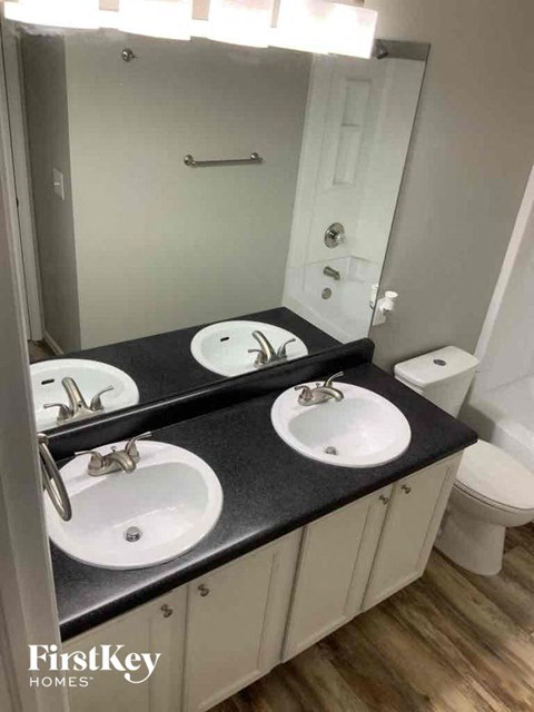 a bathroom with two sinks and a large mirror