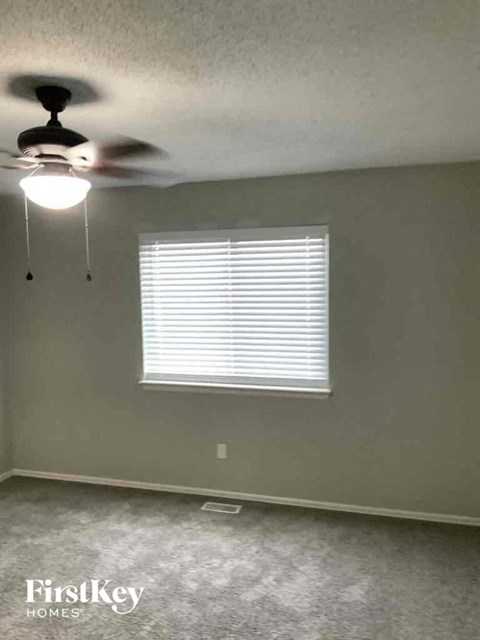 a living room with a ceiling fan and a window