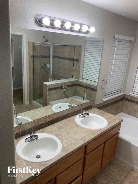 A bathroom with a double sink vanity and a large mirror above it.
