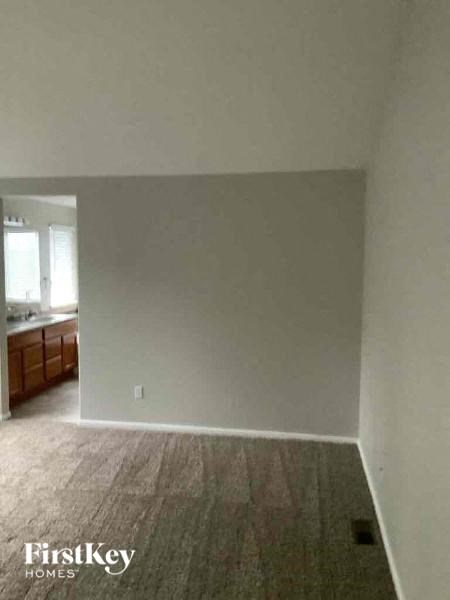 A room with a wooden floor and a wall with a light switch.