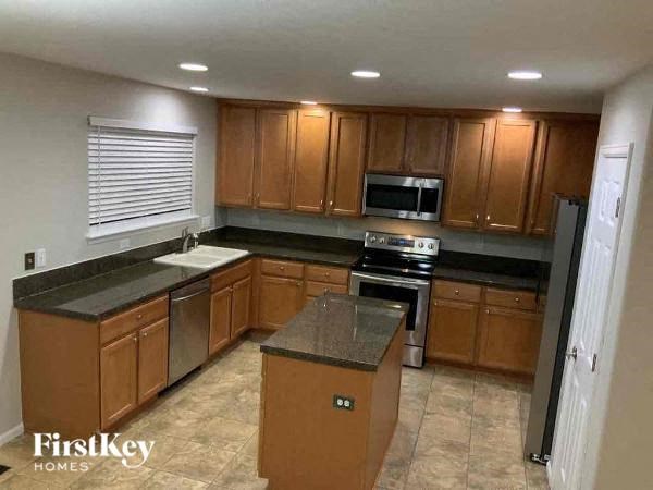 A kitchen with wooden cabinets and a black countertop.