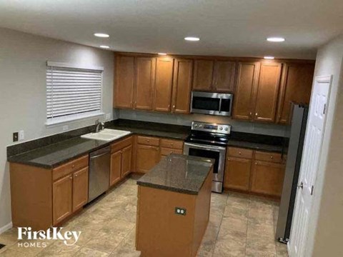 A kitchen with wooden cabinets and a black countertop.