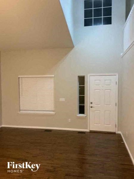A room with a white door and a window with blinds.
