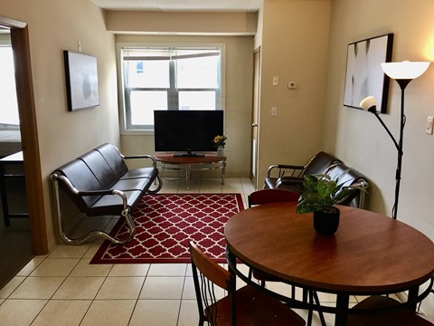 a living room with a table and chairs and a television