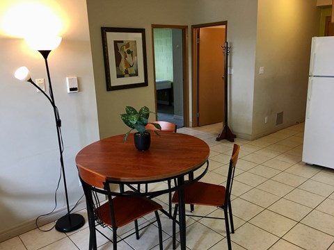 a dining room with a table and chairs and a refrigerator