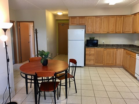 a kitchen with wooden cabinets and a table and a refrigerator