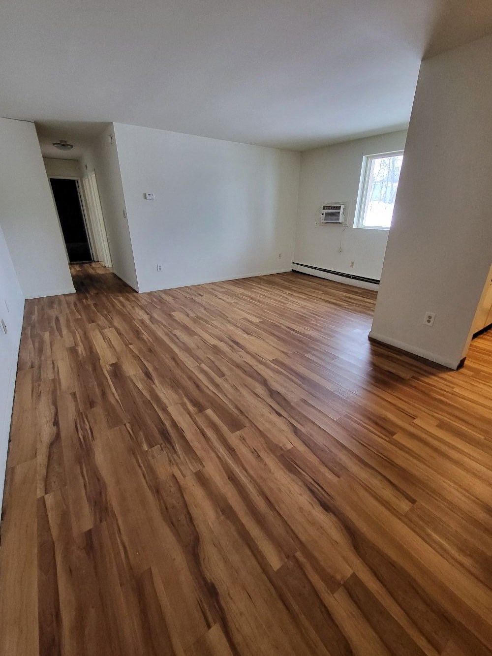 the living room and dining room of a house with wooden floors