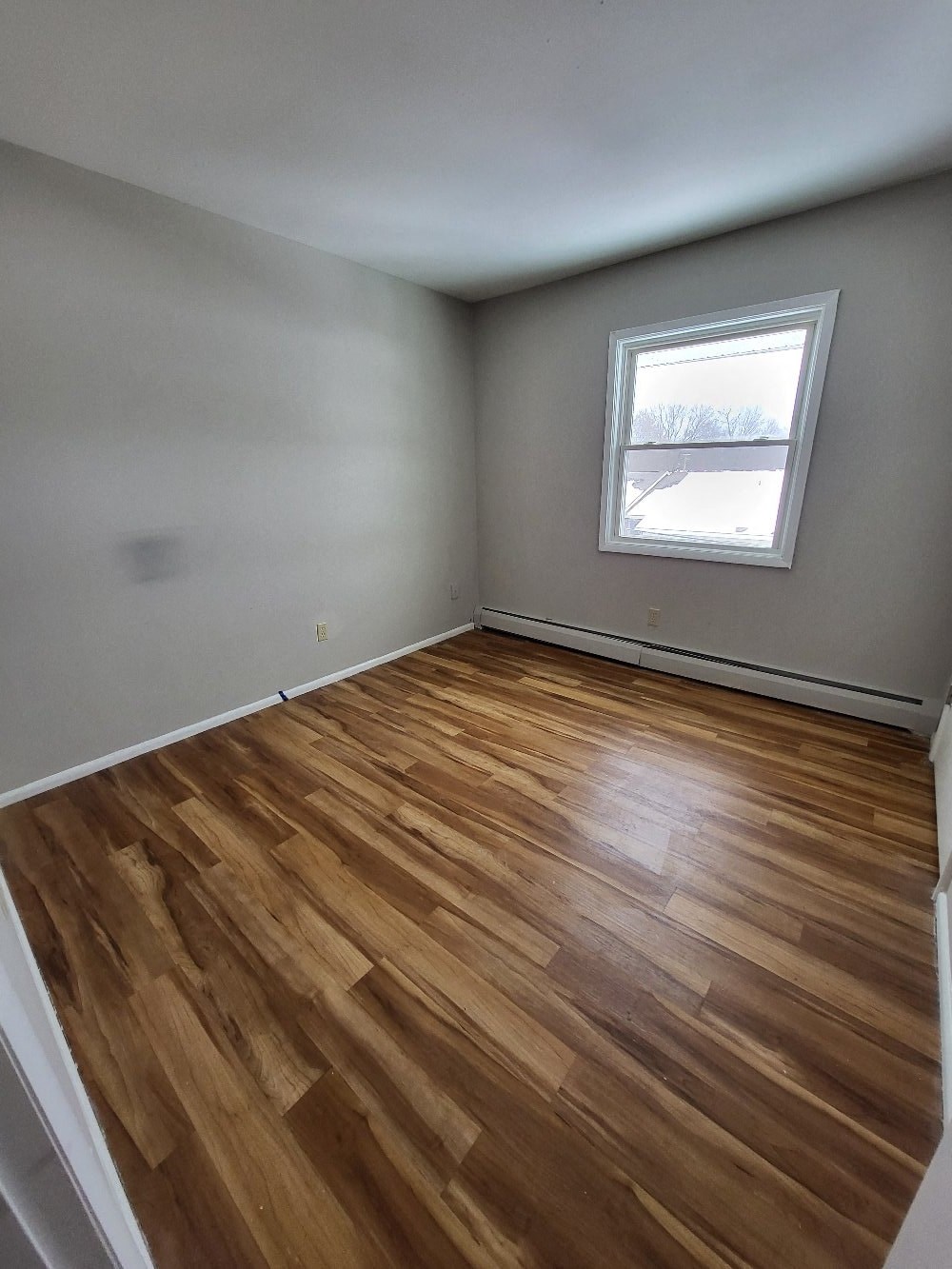 the living room of an empty house with wood floors
