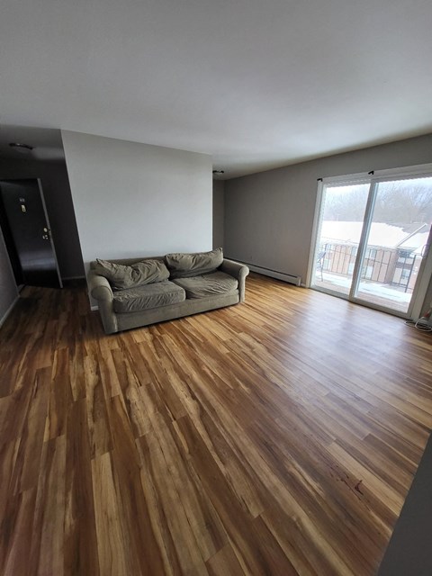 a living room with a couch and wooden floors