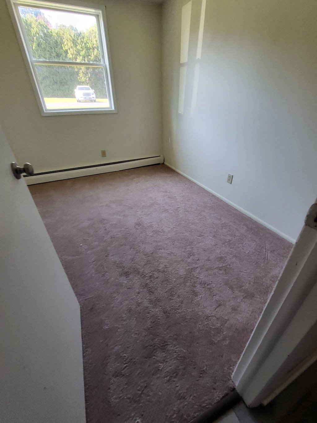 a room with a carpeted floor and a window