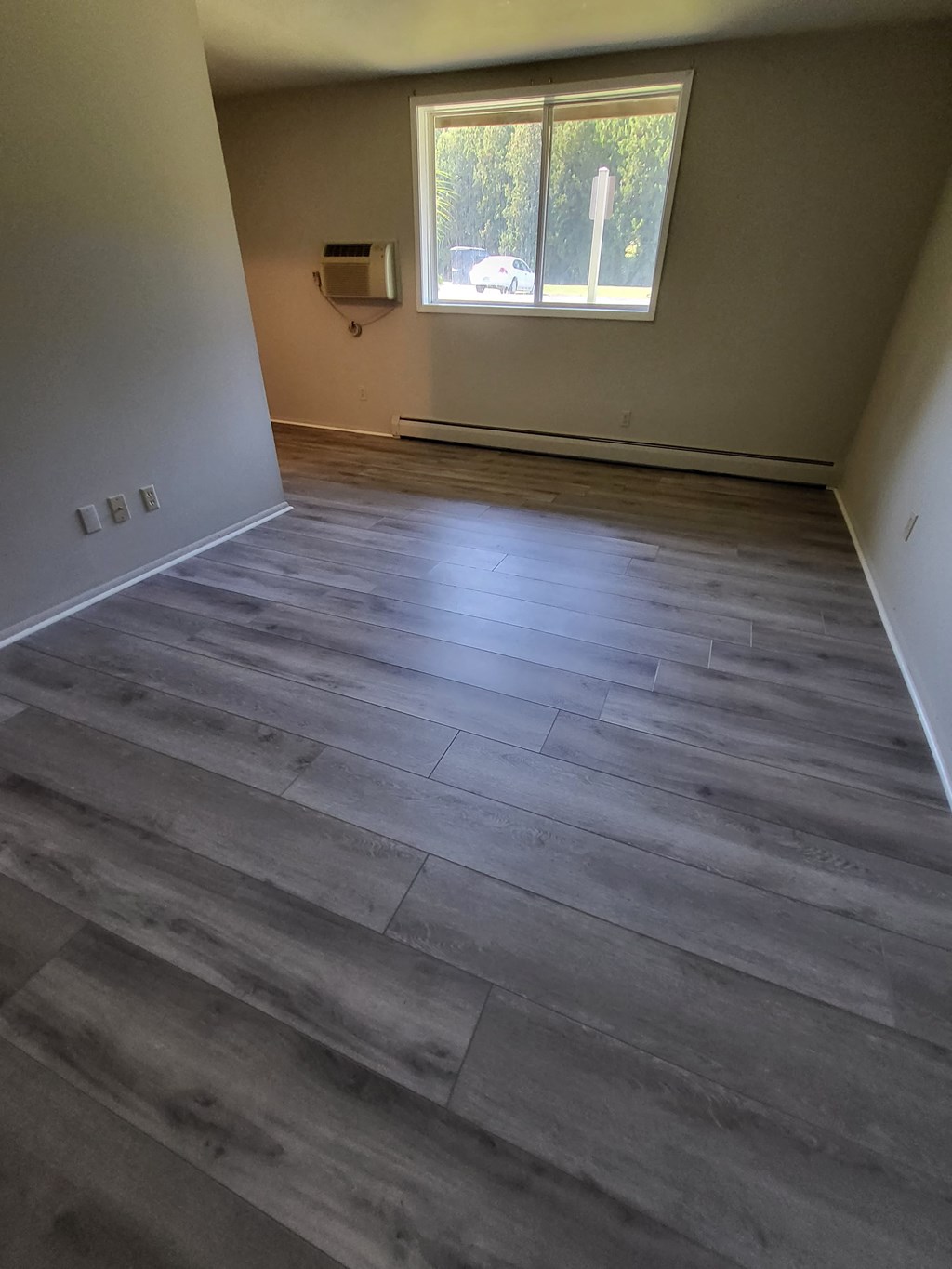 the living room has wood floors and a window