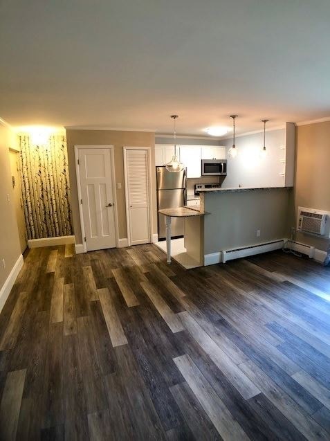 an empty living room and kitchen with wood floors