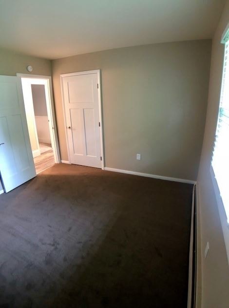 a empty room with a door and a carpeted floor