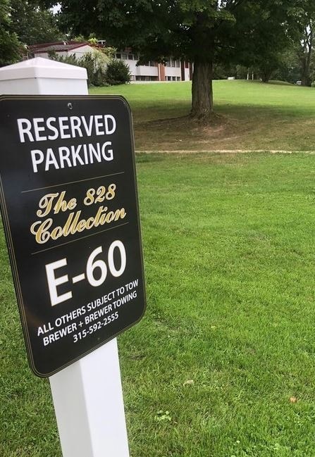 a black reserved parking sign in the grass