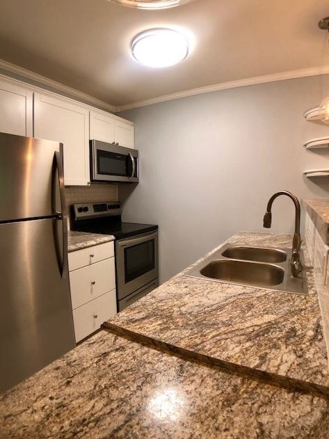 a kitchen with a sink and a stainless steel refrigerator