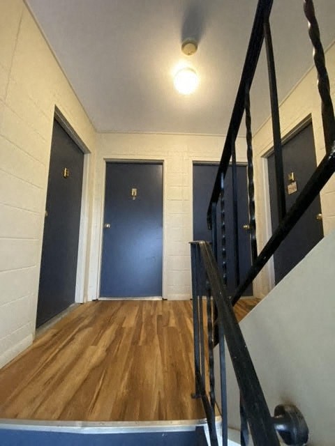 a staircase with three doors in a room with wooden floors