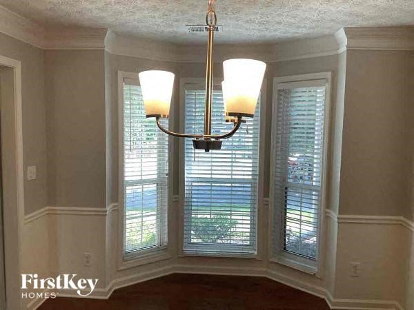 a dining room with three windows and a chandelier