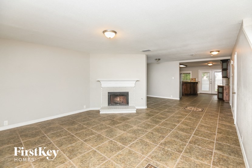 the living room has a fireplace and tile flooring