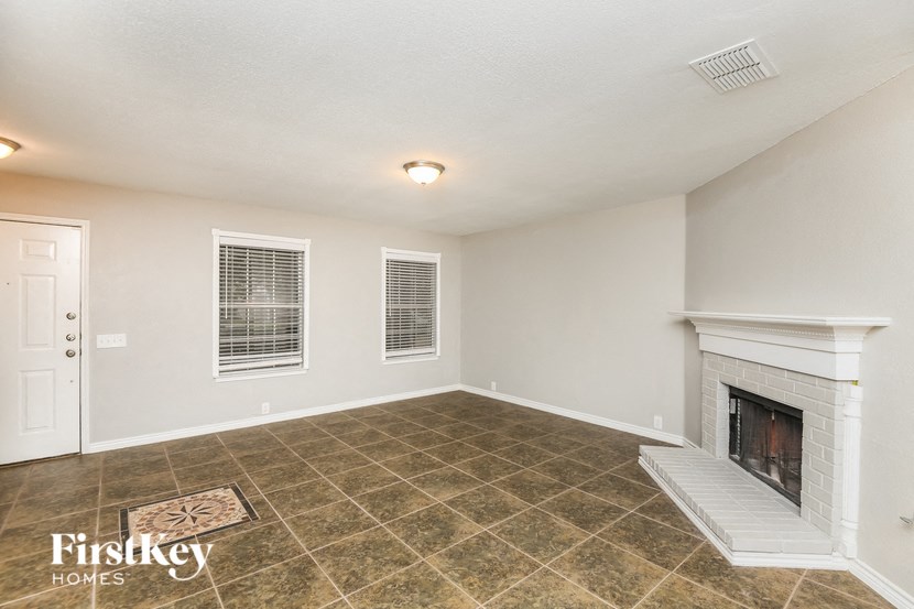 the living room has a fireplace and tile flooring