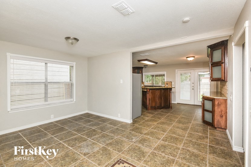 a kitchen and living room with tile flooring and a large window