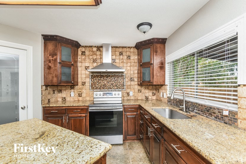 a kitchen with wood cabinets and granite counter tops and a sink