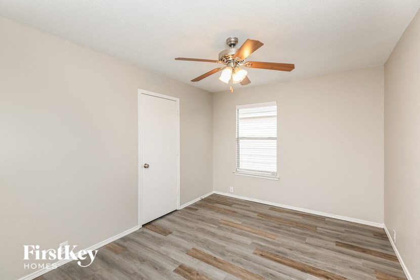 a bedroom with a ceiling fan and a white door
