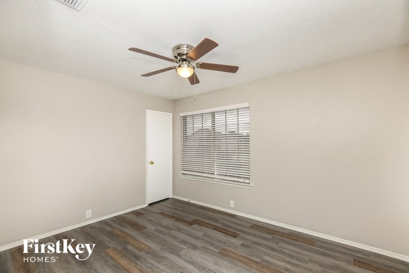 a bedroom with a ceiling fan and a window