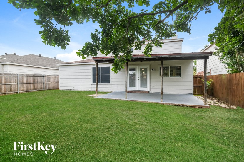 a small white house with a yard and a patio