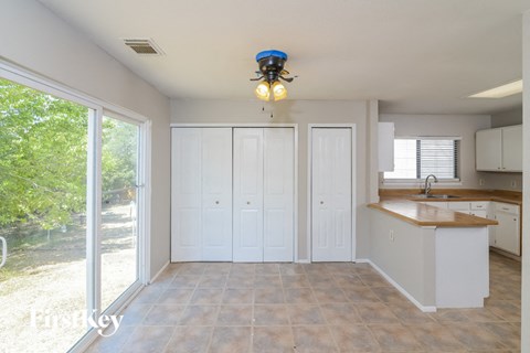 A kitchen with white cabinets and a tiled floor.