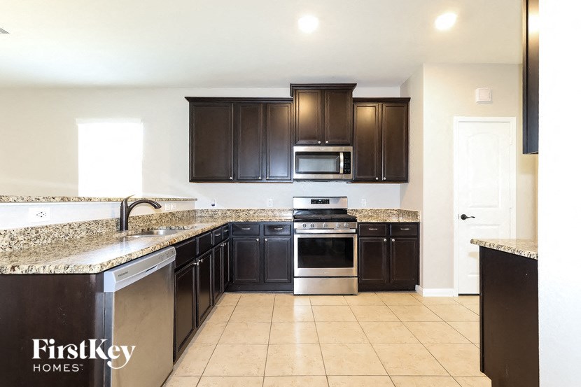 a kitchen with dark wood cabinets and granite counter tops