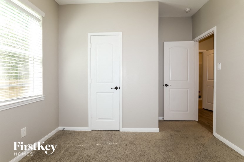 a bedroom with two doors and a closet and a window