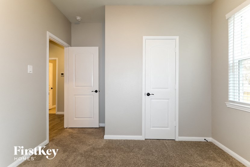 a bedroom with two white doors and a door to a hallway