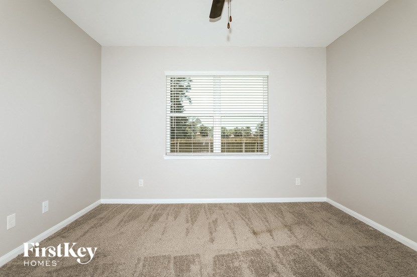 a spacious room with carpet and a window