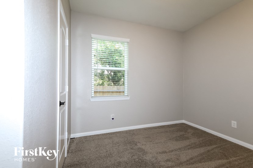 a empty room with carpet and a window