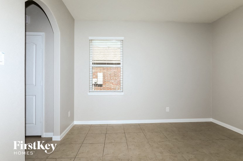 an empty room with a window and a tiled floor
