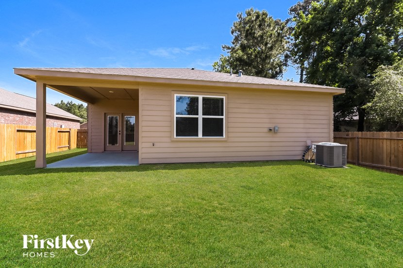 a small tan house with a lawn and a backdoor