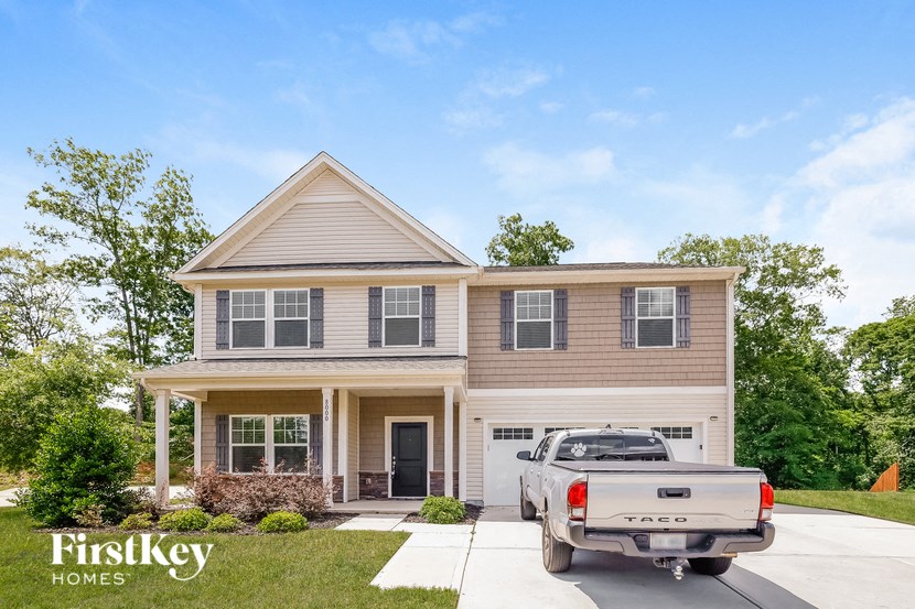 a truck parked in the driveway in front of a house