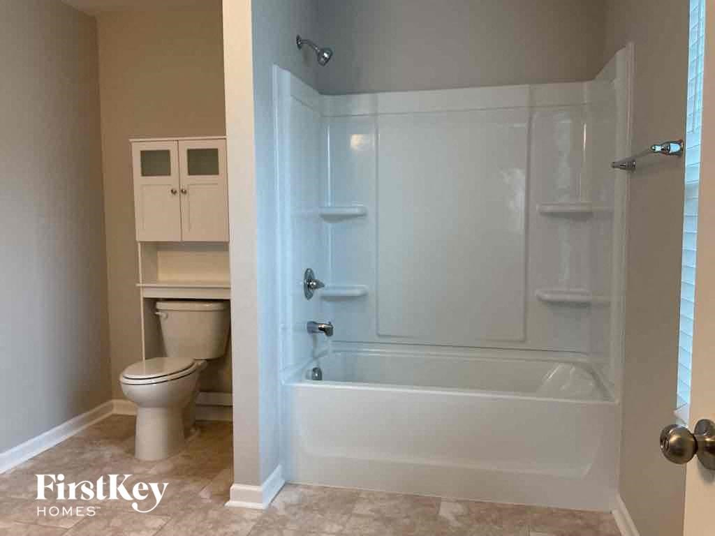 a bathroom with a shower and a toilet and a sink