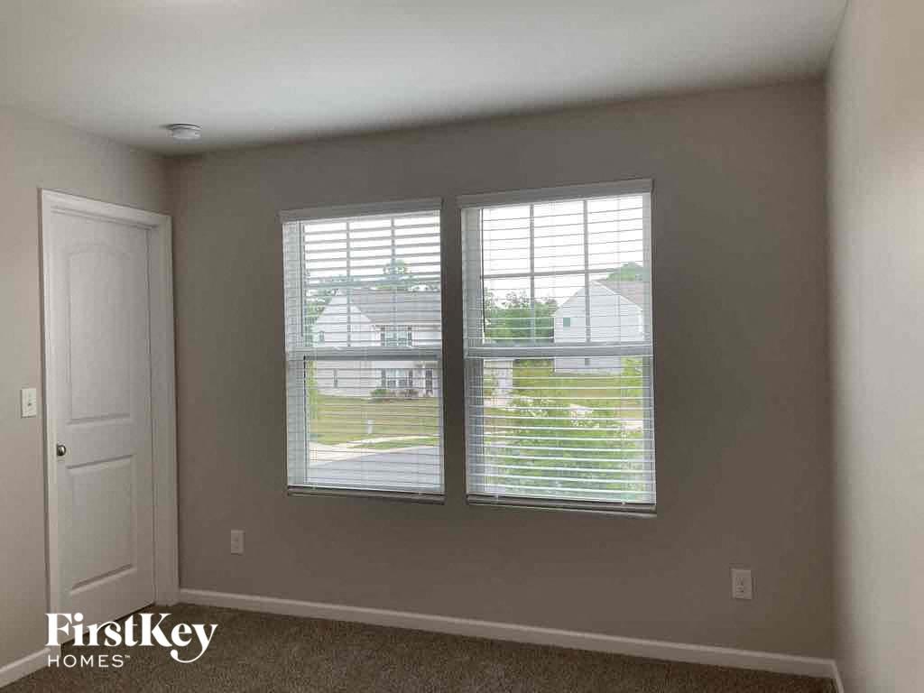 a living room with two windows and a white door
