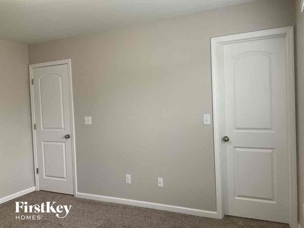 a bedroom with two white doors and a carpeted floor