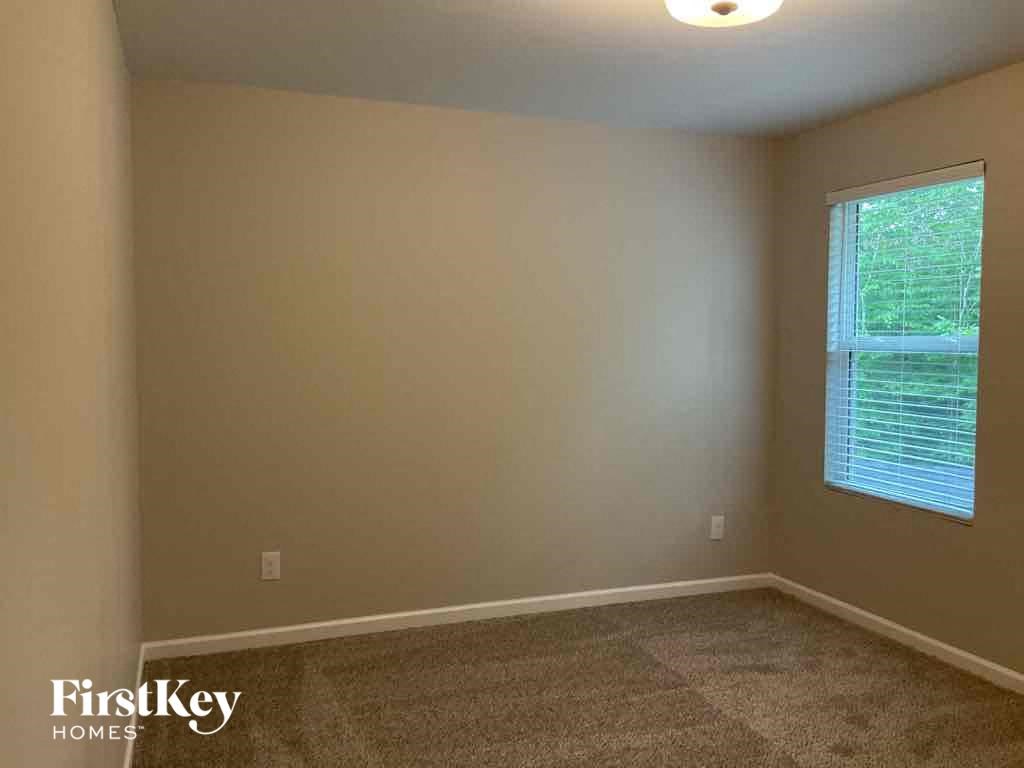 an empty room with a window and a carpeted floor