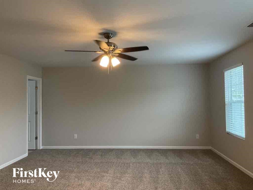 an empty living room with a ceiling fan