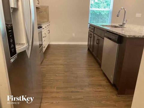 a kitchen with wooden floors and stainless steel appliances