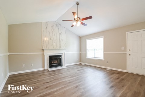 A spacious room with a fireplace and a ceiling fan.