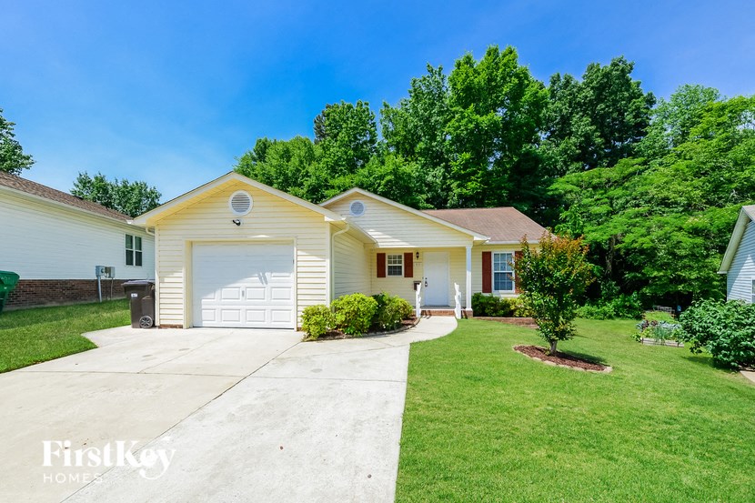 a white and yellow house with a white garage door