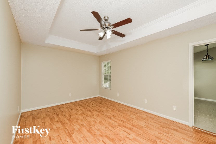 an empty living room with a ceiling fan