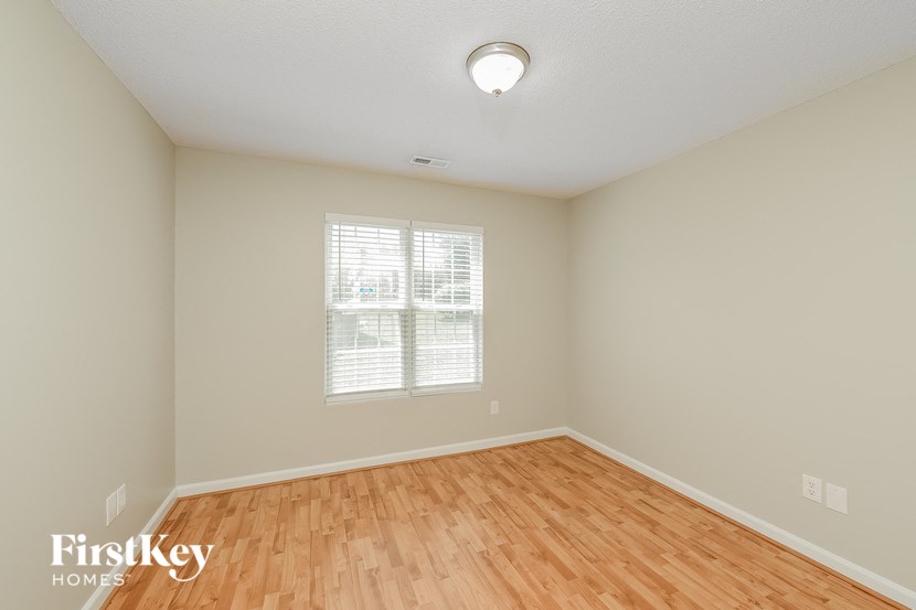 an empty living room with wood flooring and a window